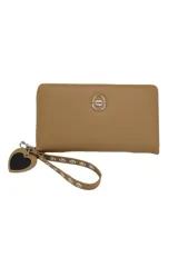 Billetera beige con cierre de cremallera, correa de muñeca desmontable con detalle de ojalillos metálicos y dije colgante en forma de corazón.