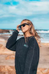 Buzo negro de corte clásico y tejido acanalado con cuello redondo y mangas largas.