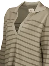 Sweater de punto color crema con rayas horizontales negras, cuello polo con escote en V y mangas largas.