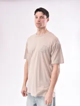 Remera color beige con estampado pequeño en el frente.