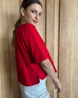Remera negra con cuello redondo y mangas cortas, con detalle de pespuntes blancos en cuello, mangas, bolsillos frontales y ruedo.