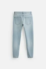 Pantalón de jean negro con corte skinny fit, cinco bolsillos, lavado con efecto roto y cierre frontal con cremallera y botón.