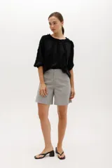 Blusa color beige de manga 3/4 confeccionada en algodón suave, con escote a la base y detalles de volados en 3D que recorren el frente, mangas y escote.