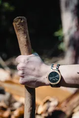 Reloj Vernoir con caja de madera de Zebrano y malla de Chacate Preto con incrustaciones de madera de Zebrano. Esfera negra con marcadores minimalistas en blanco y manecillas negras.