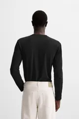 Camiseta negra de manga larga y cuello redondo, corte slim fit.