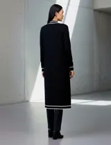 Cardigan largo de punto marca Via Milano, color negro con detalles de rayas blancas en contraste. Presenta un diseño abierto sin botones, bolsillos frontales aplicados y ribetes blancos en la apertura, puños y bolsillos.