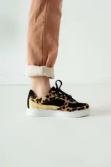 Championes negros con estampado animal print en tonos marrones y dorados.