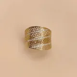 Anillo ancho de oro amarillo 10k con diseño de guarda griega y tres hileras de circonias.