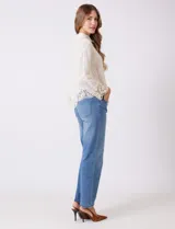 Camisa de algodón color naranja, con bordado suizo y encaje calado. Tiene cuello con solapa, botones frontales, mangas largas con terminación de encaje y ruedo asimétrico con galón de encaje.