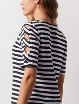 Remera de algodón a rayas horizontales rosas y blancas, con cuello redondo y mangas cortas con detalle de aberturas entrelazadas.
