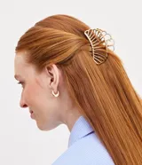 Pinza de pelo dorada con forma de concha hueca.