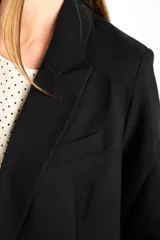 Blazer color crema de poliéster y viscosa, de corte oversize con solapas y doble botonadura.