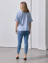 Blusa celeste con rayas verticales blancas, escote redondo con cordón ajustable y mangas cortas con volados.