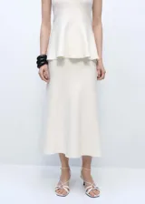 Falda midi color crudo de tejido de punto fino, con cintura elastizada y corte peplum.