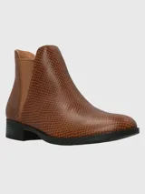 Bota tipo chelsea de cuero color marrón con textura grabada tipo reptil. Presenta paneles elásticos laterales a tono y suela de caucho termoplástico con tacón bajo.