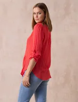 Blusa blanca de gasa bambula, marca Zac & Rachel. Cuello a la base, escote en V con apertura y botones. Largo de manga regulable con presilla y botón.
