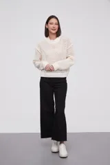 Sweater color blanco crudo con diseño de tramas abiertas, de corte holgado y manga larga.