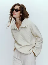 Sweater acolchado en tono crudo con cuello alto y cierre, de corte holgado.