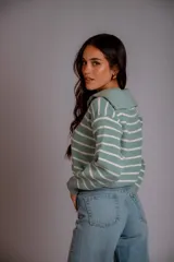 Sweater de punto color beige con rayas horizontales blancas, cuello polo con cierre de cremallera y mangas largas.