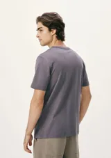 Remera gris con cuello redondo y manga corta. Presenta un pequeño parche con logo en el pecho.