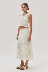 Top tejido de punto calado color crudo con diseño de flores, escote redondo y lurex en el escote.