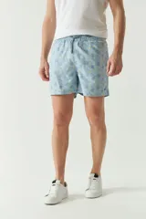 Short de baño celeste con estampado de hojas, cintura elástica con cordón ajustable, dos bolsillos laterales y uno trasero.