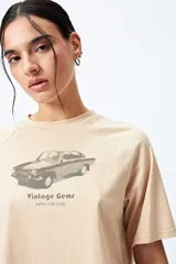 Remera cropped blanca de mangas ranglan con estampa frontal de un auto antiguo y texto "Vintage Gems / retro car club".