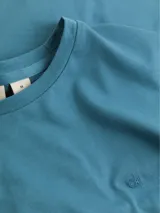 Remera celeste de algodón orgánico de transición, corte regular, cuello redondo y manga corta. Presenta el micrologo de Calvin Klein bordado en el pecho.