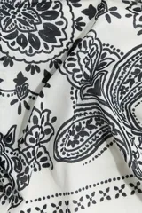 Pañuelo cuadrado de algodón color blanco con estampado paisley en negro y borde con diseño geométrico.