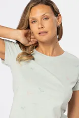Remera color beige con estampado de aves en tonos celeste, lila y dorado.