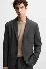 Blazer slim fit color gris oscuro confeccionado en tejido con viscosa. Tiene cuello con solapas de muesca, manga larga con puño abotonado, bolsillo de vivo en pecho, bolsillos de solapa en cadera, bolsillo interior, bajo con aberturas en espalda y cierre frontal con botones.