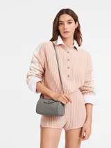 Bandolera Longchamp modelo Le Pliage Xtra XS, color rosa pálido, con correa ajustable y cierre de solapa con botón a presión.