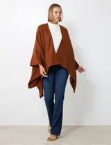 Ruana de tejido suave color morado oscuro, con cuello redondo y corte amplio tipo capa.