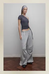 Pantalón de jogging gris melange, corte amplio, con cintura elástica, bolsillos laterales y pinzas en las rodillas.