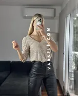Blusa negra de lentejuelas con escote en V y mangas 3/4 abullonadas.
