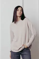 Sweater color crema de tejido de punto con hilos metalizados, corte relajado, hombros caídos y terminaciones clásicas.