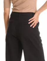 Pantalón palazzo negro de viscosa, tiro alto con pretina lisa y pasadores para cinturón. Diseño con pinzas frontales, bolsillos laterales de corte vertical y bolsillos ojal simulados en la parte trasera.