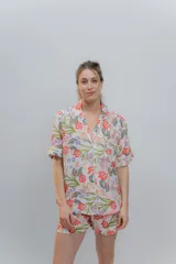 Conjunto de pijama de algodón a rayas verticales rosas y blancas, con detalles en celeste. Incluye camisa de manga corta con botones y bolsillo en el pecho, y shorts con cintura elástica.