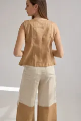 Pantalón ancho de corte recto con distintos cortes combinando colores beige, negro y marrón.