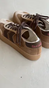 Zapatillas de cuero con detalles de zigzag y combinación de texturas y colores.