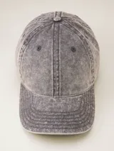Gorra de gabardina color gris oscuro con visera curva y etiqueta con logo de la marca en el lateral.