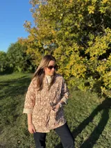 Chaqueta acolchada con estampado ikat en tonos beige y marrón, de corte holgado y cuello mao.