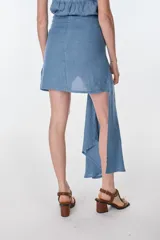 Conjunto de camisa celeste de mangas largas abullonadas y falda turquesa con detalle fruncido y lazo en el lateral.