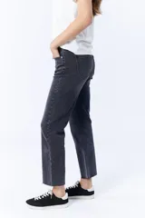 Pantalón de jean negro con corte cropped y flare, de tiro alto y con terminación desflecada.