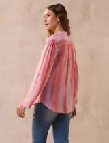Blusa de gasa estampada con cuello a la base, escote en V y botones. Delantera con detalle plisado y mangas largas regulables con presilla y botón.
