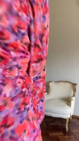 Vestido corto rojizo con estampado floral, escote fruncido con abertura, mangas largas abullonadas y falda con tajo lateral.