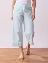 Pantalón capri de algodón a rayas verticales celestes y blancas, marca Ruby Rd. Tiene pretina con botón y cierre, pretina trasera elastizada, bolsillos delanteros y traseros, y terminación de ruedo desflecado.