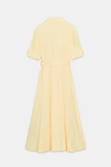 Vestido midi camisero color ladrillo, confeccionado en popelina de algodón. Presenta cuello solapa, manga corta con puños abotonados, bolsillos laterales ocultos y bolsillos de parche con solapa en el pecho. Incluye cinturón lazada en el mismo tejido y cierre frontal con botones ocultos.