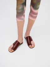 Sandalias de cuero color marrón con tira ancha sobre el empeine y abertura para el dedo gordo.