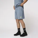 Bermuda deportiva azul con cintura elástica con diseño geométrico, detalle de línea amarilla en el lateral y logo de la marca en la pierna izquierda.